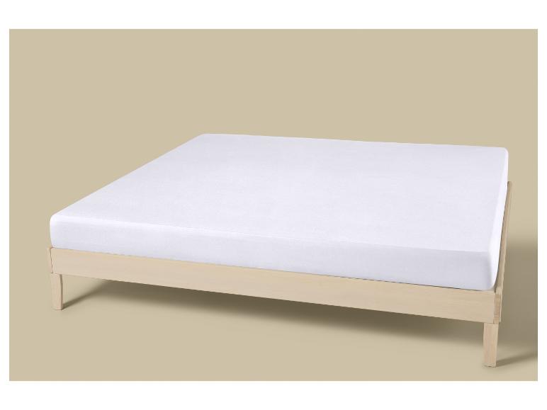 Wit matras op een houten bedframe.