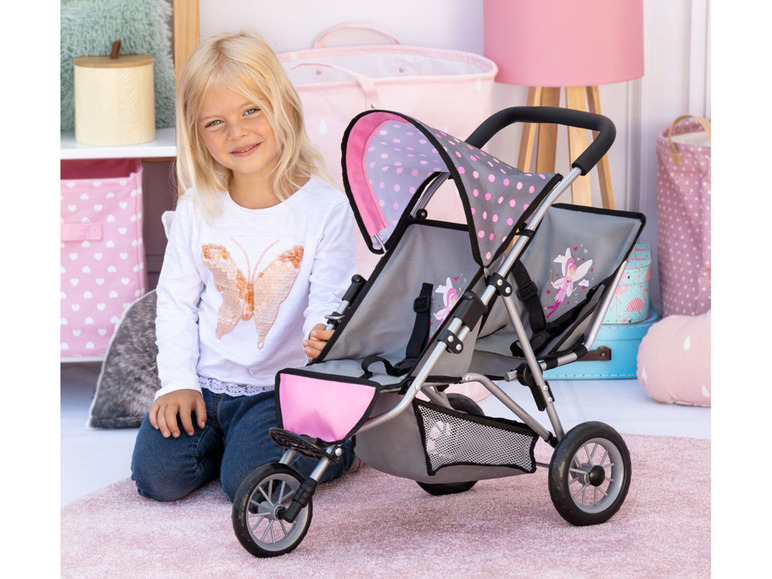 Een meisje met een roze poppenwagen met een vlindermotief.