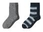 Twee paar antislipsokken, één grijs en één met blauwe en witte strepen.