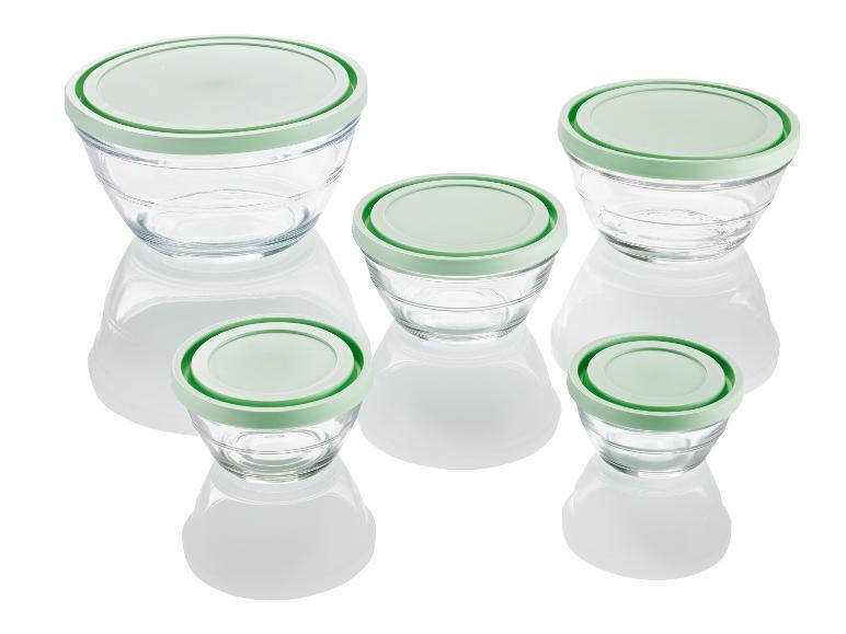 Vier glazen kommen met groene deksels.