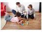 Familie speelt op de vloer met letterblokken en kaarten.