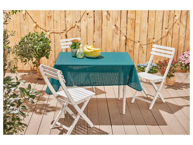 Witte opklapbare tafel en stoelen, turquoise kleed, buitensetting.