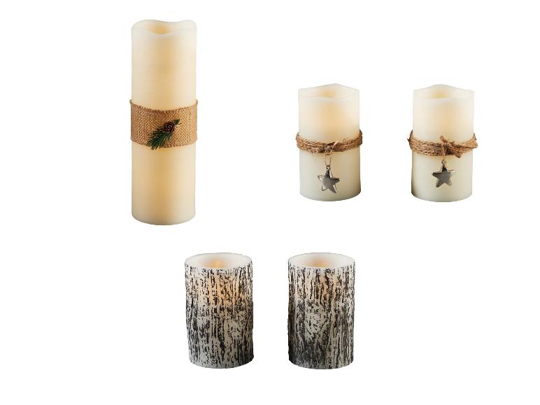 Diverse LED-kaarsen, waaronder een hoge met juten touw en dennenappel, twee kleinere met sterhanger en twee met basttextuur.
