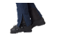 Blauwe skibroek met ritsen en zwarte skischoenen.