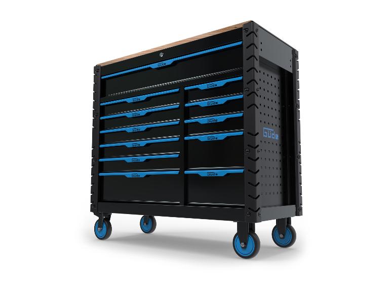 Zwarte metalen gereedschapswagen Güde met blauwe laden op wielen.