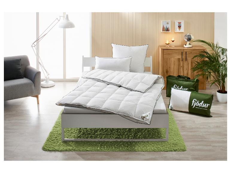 Slaapkamer met eenpersoonsbed, Fjödur dekbed, kussens en groen vloerkleed.
