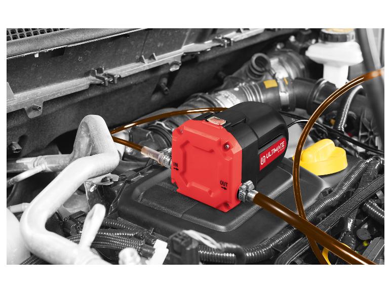 Rode en zwarte Ultimate Speed olieafzuigpomp in de motorruimte van een auto.