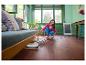 Vrouw maakt houten vloer schoon met vloerreiniger in lichte woonkamer.