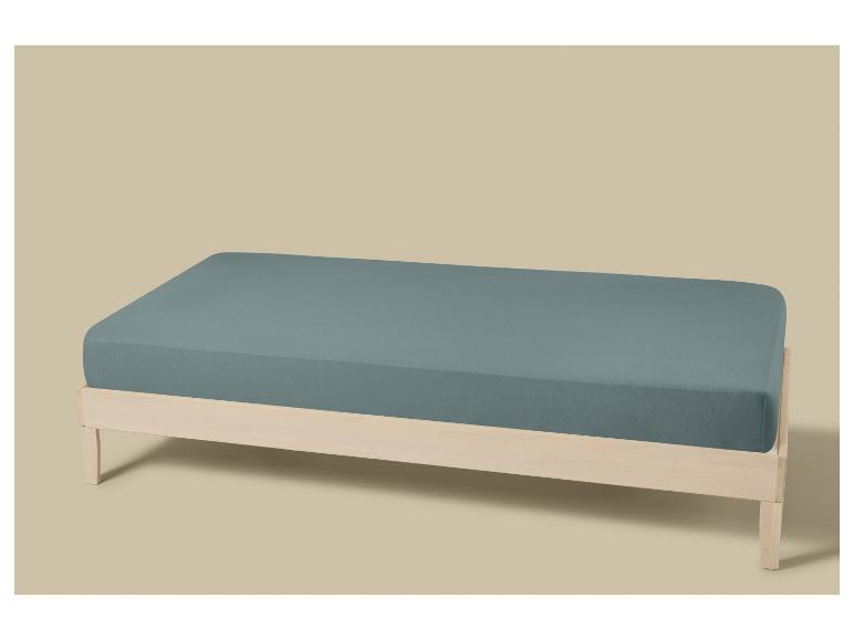 Licht houten bed met matras en blauwgrijs hoeslaken