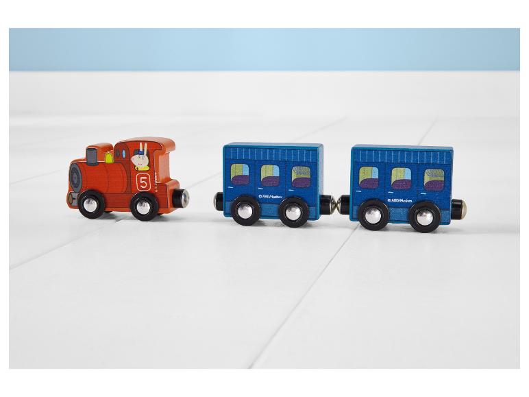 Houten speelgoedtrein met oranje locomotief en twee blauwe wagons op een witte vloer.