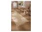 Beige vloerkleed met geometrisch patroon op houten vloer in hal.