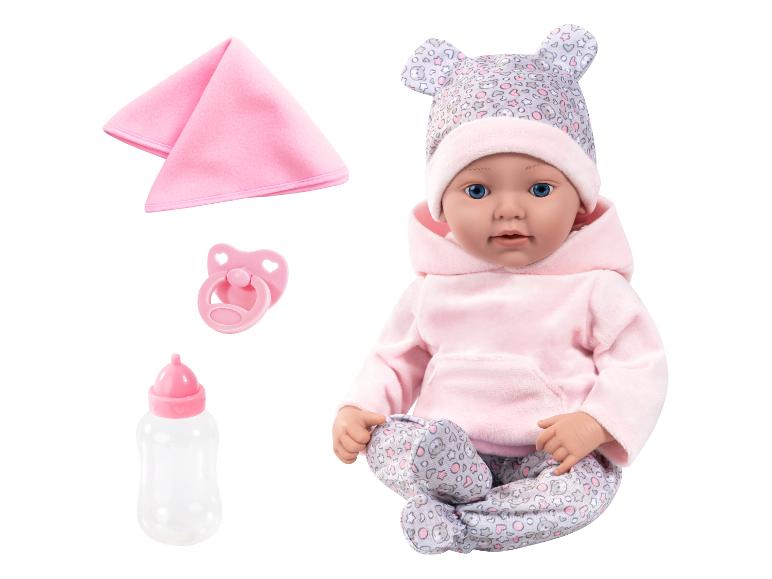 Babypop in roze hoodie en pyjama met patroon, met speen, fles en deken.