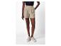 Beige linnen shorts en platte sneakers.