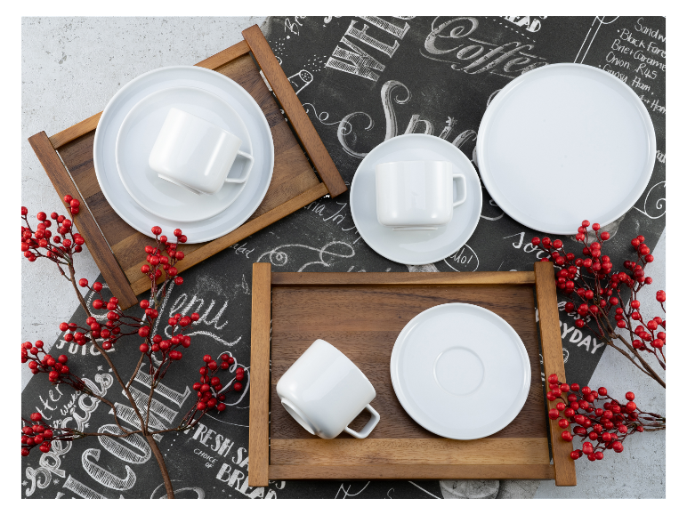 Witte kopjes, schoteltjes en borden op een houten dienblad.