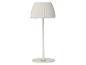 Witte tafellamp met geplooide lampenkap en ronde voet.