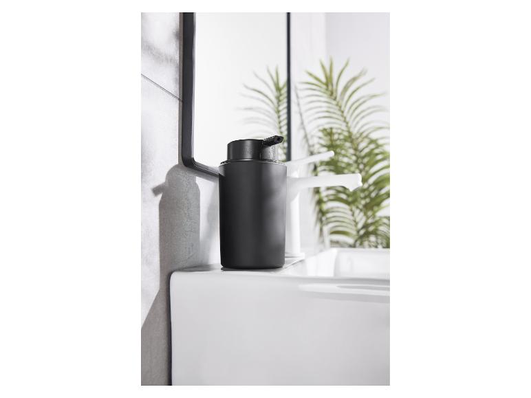 Een elegante zwarte zeepdispenser op een modern wit wastafel.