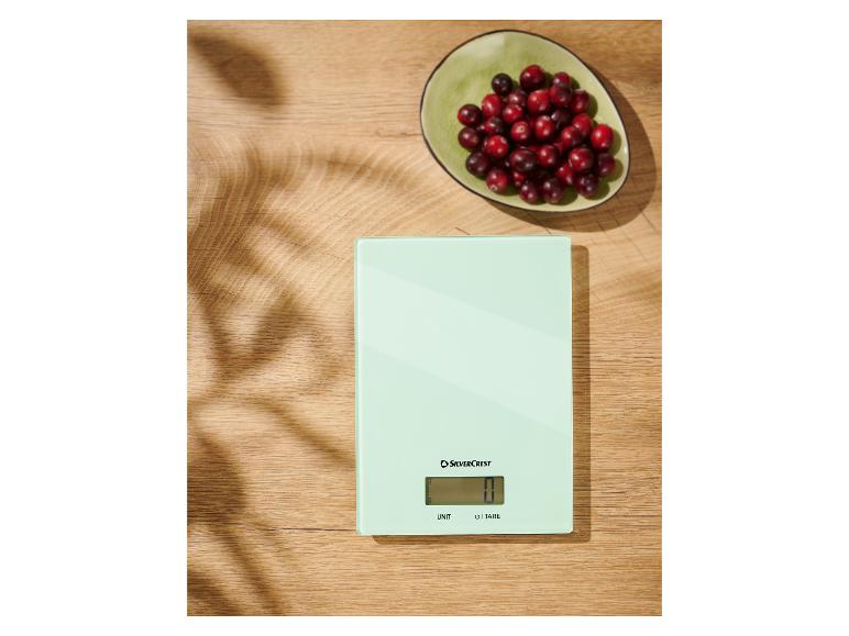 Een SilverCrest keukenweegschaal op een houten tafel met een schaal cranberry's.