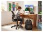 Jongen tekent aan houten bureau met rugzak en videogame-thema decoratie.