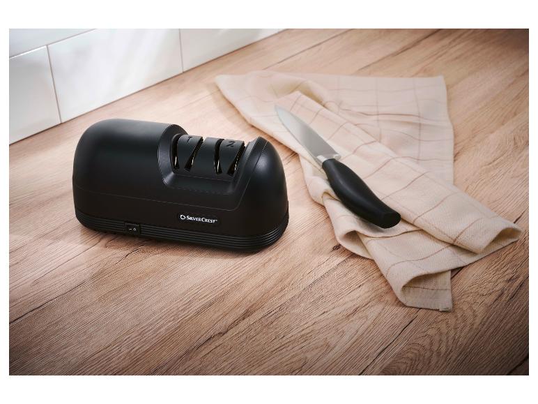 SilverCrest elektrische messenslijper op een houten aanrecht met een mes en een doek.