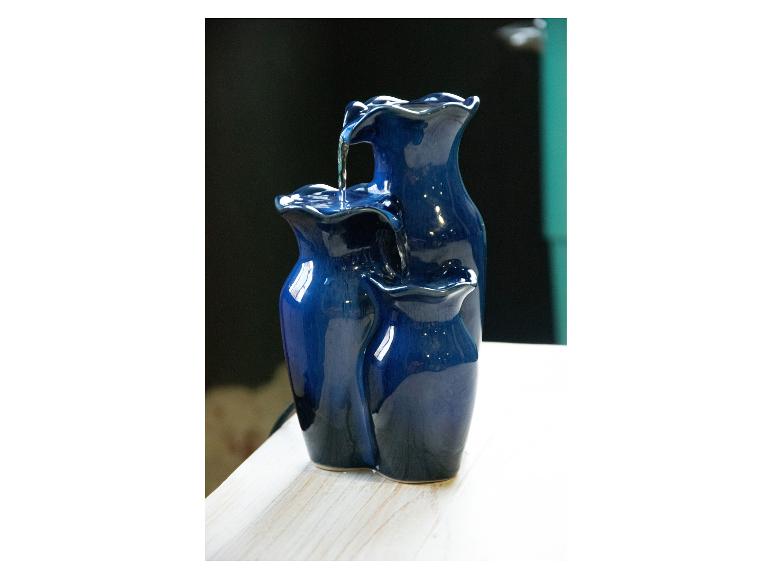 Blauwe keramische drielaagse binnenfontein op een houten oppervlak.