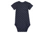 Een donkerblauwe romper met witte stippen.