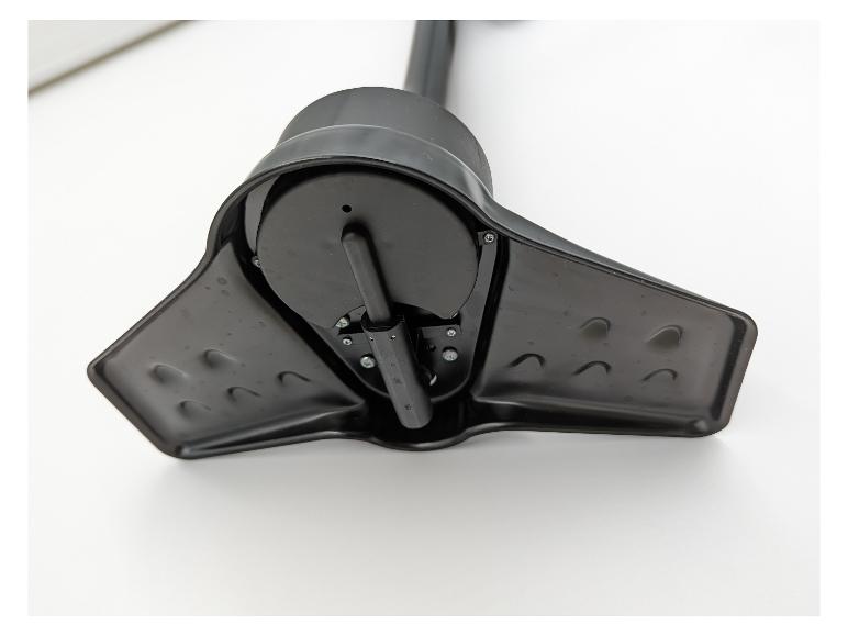 Close-up van een zwarte plastic basis met een centraal draaimechanisme en schroeven