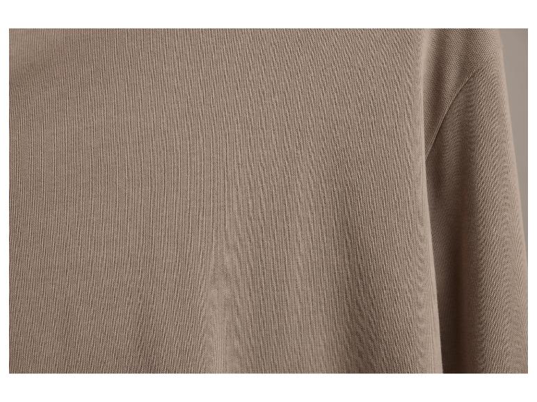 Close-up van een beige longsleeve shirt.