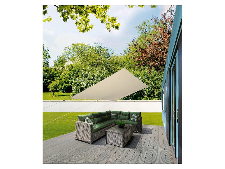 Beige zonnescherm en rotan tuinmeubilair op een terras.