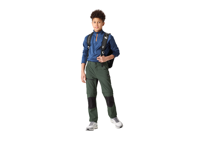 Jongetje in blauw shirt en groene broek met rugzak.