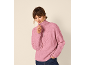Vrouw in roze gebreide trui met halve rits en jeans, kijkt naar beneden en past de rits aan.