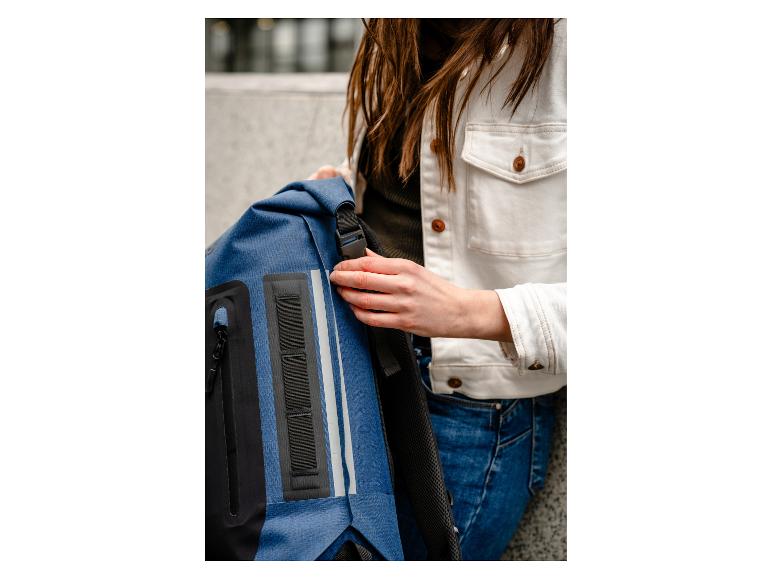 Donkerblauwe rugzak en wit jeansjack.