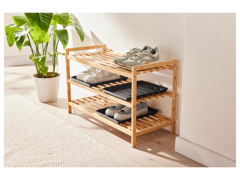 Een drielaags schoenenrek van bamboe met plastic inlegbakken.