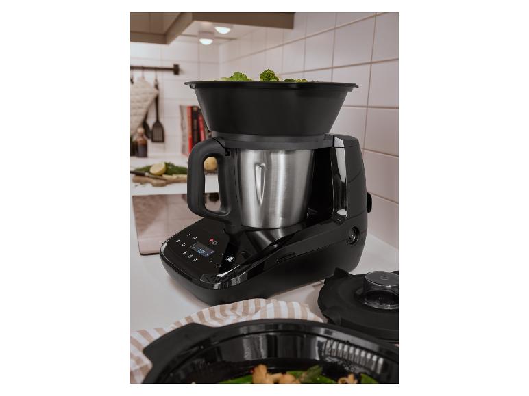 Keukenmachine met stoommand vol broccoli op een aanrecht.