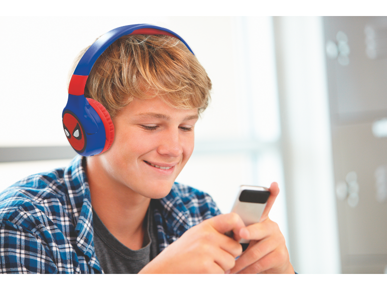 Tiener met koptelefoon en geruit overhemd gebruikt een smartphone.
