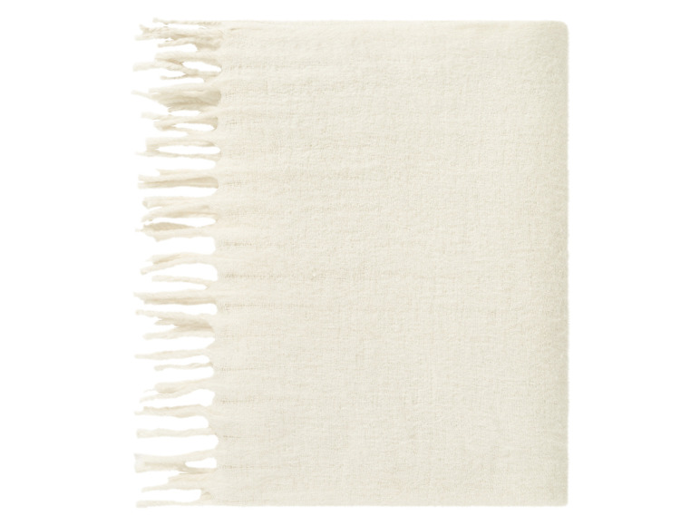 Een wit wollen plaid met franjes.