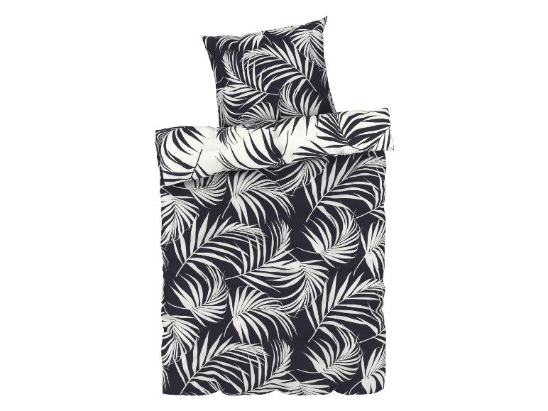 Een dekbedovertrek en kussensloop met een tropisch palmbladerenpatroon.