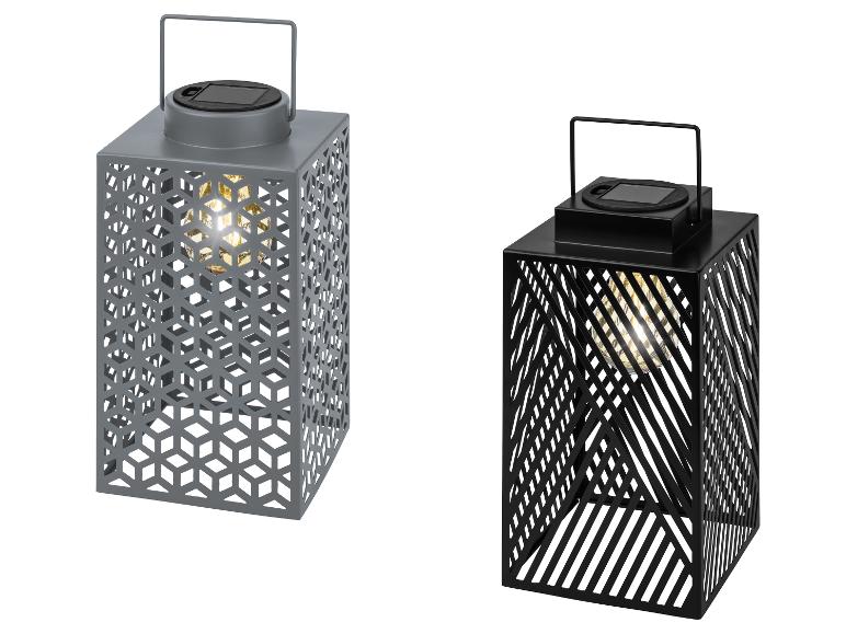 Twee grijze en zwarte zonnelantaarns met uitgesneden patronen en gloeiende lampen.