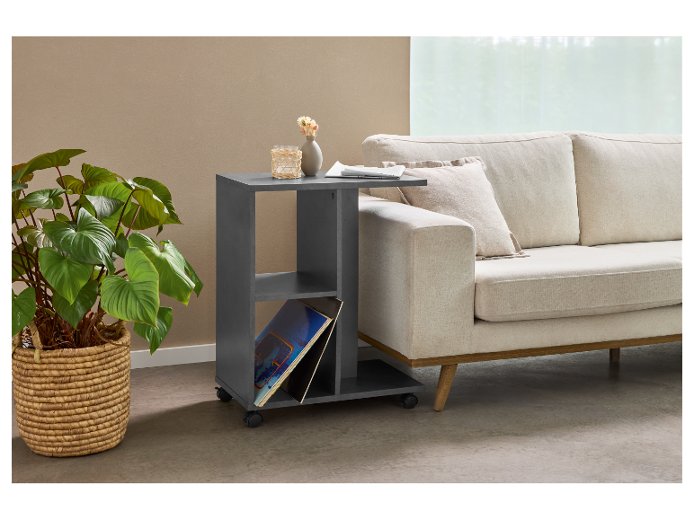 Modern bijzettafeltje op wielen, naast een beige bank.