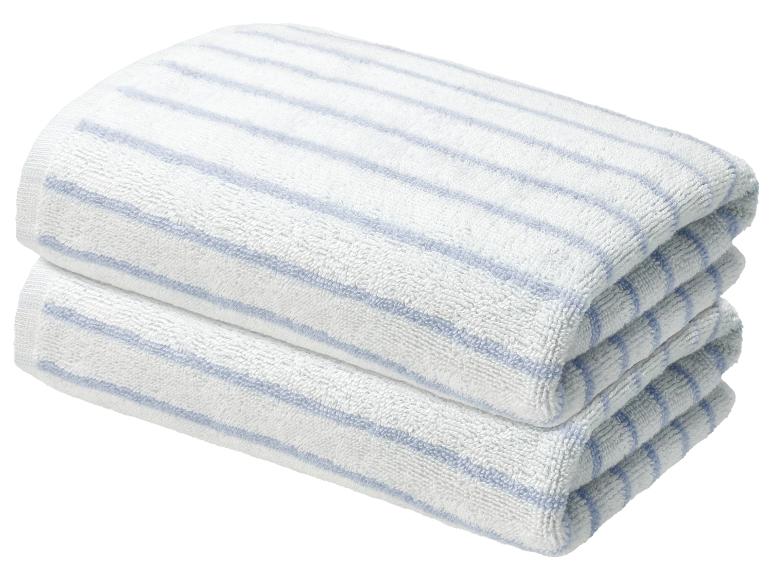 Twee witte handdoeken met blauwe strepen opgestapeld