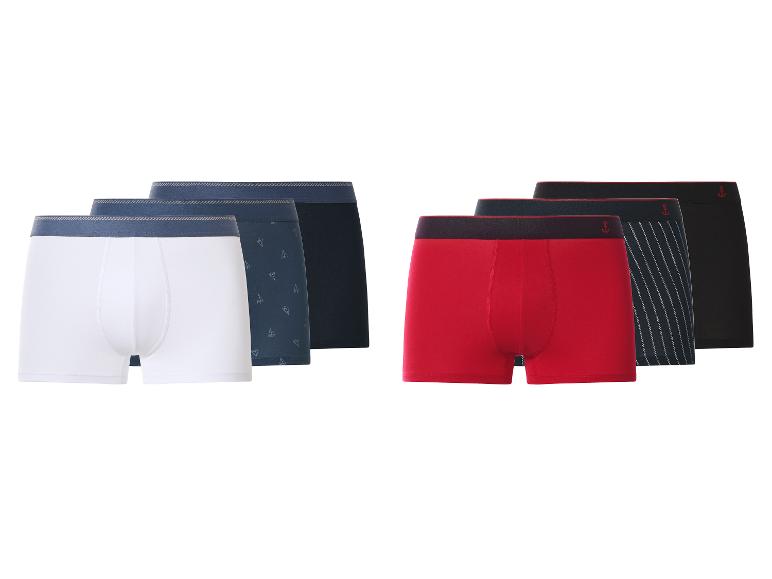 Zes paar herenboxershorts in wit, blauw, rood en zwart, sommige met patronen.