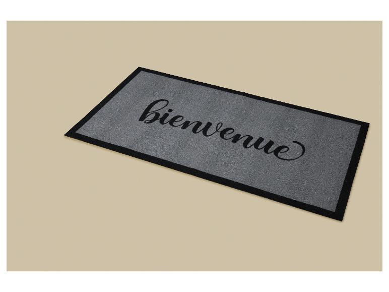 Grijze deurmat met de tekst 'bienvenue' (welkom) in zwart cursief schrift.
