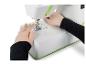 Handen rijgen een witte en groene naaimachine met rode draad.