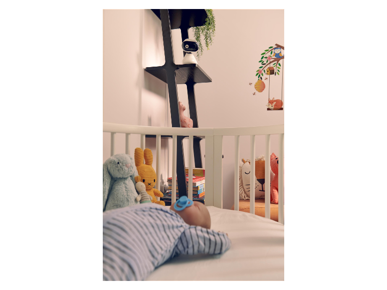 Kinderkamer met babyfoon en slapende baby.