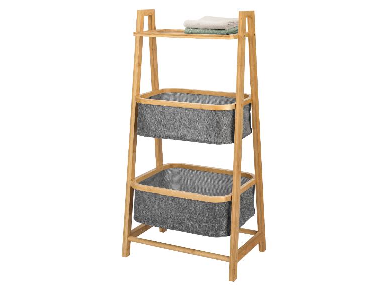 Bamboe rek met twee grijze stoffen manden en handdoeken op de bovenste plank.