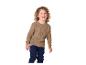 Kind in bruine trui en donkerblauwe broek lacht.