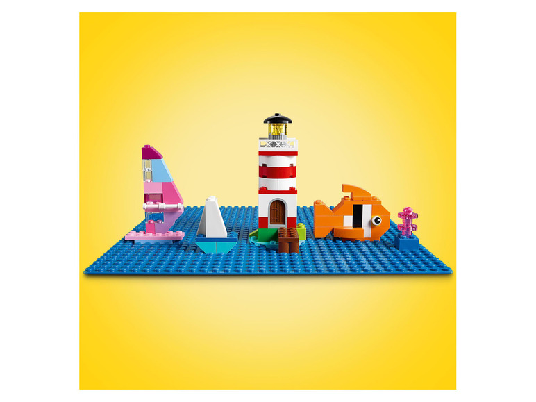 Lego Classic set met een vuurtoren, boot en vis.