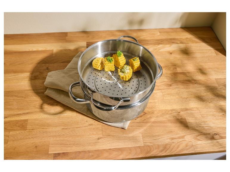 Maïs in een roestvrijstalen stoompan op een houten aanrecht.