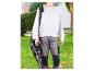 Persoon met bladblazer en accu aan schouderband, staand op een gazon.