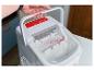 Een witte Coca-Cola ijsmachine met een handvat.