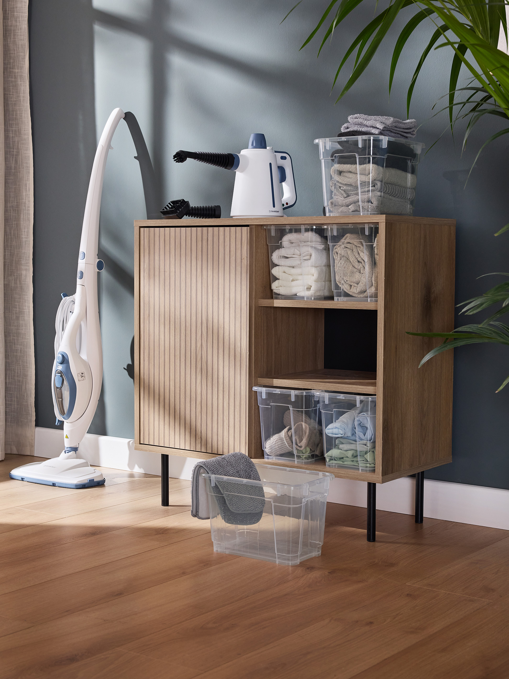 Stoomreiniger en handstoomreiniger met transparante opbergdozen en handdoeken.